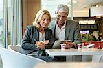 Businesspeople using digital tablet in cafeteria