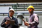 Factory workers with digital tablet and clipboard in factory