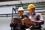 Factory workers discussing with each other in factory