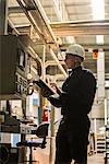 Factory worker using digital tablet in factory