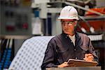 Factory worker with clipboard in factory
