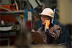 Factory worker using mobile phone in factory