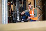 Worker sitting with clipboard in warehouse