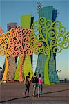 People in the evening by the lakeside malecon, with metal trees illuminated at night, Managua, Nicaragua, Central America