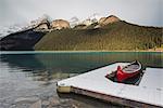 Red canoe and dock in Lake Louise with snow-covered mountains, Banff National Park, UNESCO World Heritage Site, Alberta, The Rockies, Canada, North America