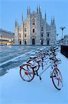 Parked bicycles covered by snow in Piazza Duomo, Milan, Lombardy, Northern Italy, Italy, Europe