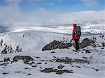 A winter walker on the summit of The Cairnwell in the Cairngorm National Park looking over to Carn a' Gheoidh, Cairngorm National Park, Scotland, United Kingdom, Europe
