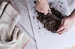 A cook chopping chocolate pieces with a large cleaver.