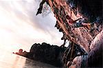 Rock climbing on limestone rock at sunset, Tonsai, Krabi, Thailand