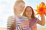 Girls with pinwheel on seaside holiday