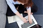 Woman sitting on floor using laptop