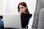 Woman using laptop on sofa