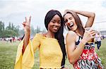 Friends drinking and dancing with arms raised in music festival