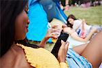 Woman using cellphone at music festival, friends in background