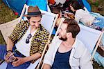 Friends sitting in deck chairs in music festival