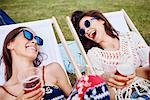 Friends sitting in deck chairs in music festival