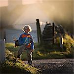 Portrait of young boy in rural setting, holding skateboard, Lahinch, Clare, Ireland