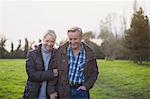 Happy, affectionate mature couple walking on park