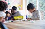 Father and children coloring at table