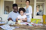 Parents and daughter coloring at table