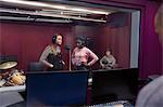 Teenage musicians recording music, singing in sound booth