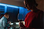 Woman drinking wine at party in apartment