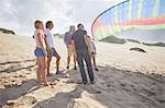 Paragliders with parachute on sunny beach