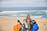 Portrait smiling, confident female paraglider with equipment on sunny ocean beach