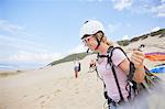 Smiling female paraglider with equipment on beach