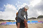 Male paraglider preparing on sunny beach