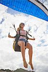 Smiling female paraglider mid-air