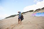 Male paraglider preparing equipment on beach