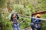 Woman zip lining above trees