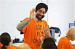 Happy hackers high-fiving, coding for charity at hackathon