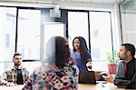 Creative businesswoman leading conference room meeting