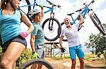 Carefree friends carrying mountain bikes