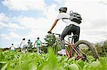 Friends mountain biking in rural field