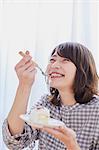 Young Japanese woman eating cake