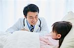 Japanese doctor with a patient in bed