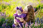 Beautiful young mother and her daughter having fun at the lavender field. Mothers Day