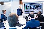 Business man making a presentation at office. Business executive delivering a presentation to his colleagues during meeting or in-house business training, explaining business plans to his employees.