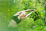 Young caucasian lady is practicing half moon yoga pose in the nature.