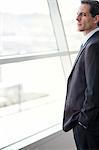 Closeup of a Caucasian businessman looking out the widow of a conference centre lobby.