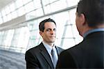 Businessman looking at the camera during discussion in a conference centre lobby.