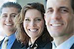 A closeup portrait of a row of multi ethnic business people, with focus on the Caucasian businesswoman.