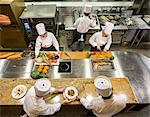 A view looking down on a crew of chefs working in a commercial kitchen,