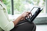 A closeup of the hands of a black businesswoman working on a notebook computer.