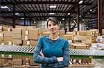 A Caucasian female warehouse worker in a distribution warehouse.