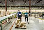 Caucasian male and female workers in a large distribution warehouse.