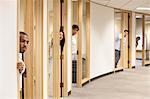 Individual business people looking out the doorway of their offices.